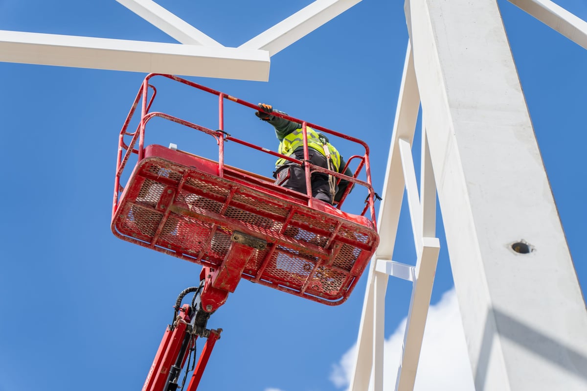Arbeiter in einem Arbeitskorb einer Höhenarbeitsbühne bei Montagearbeiten